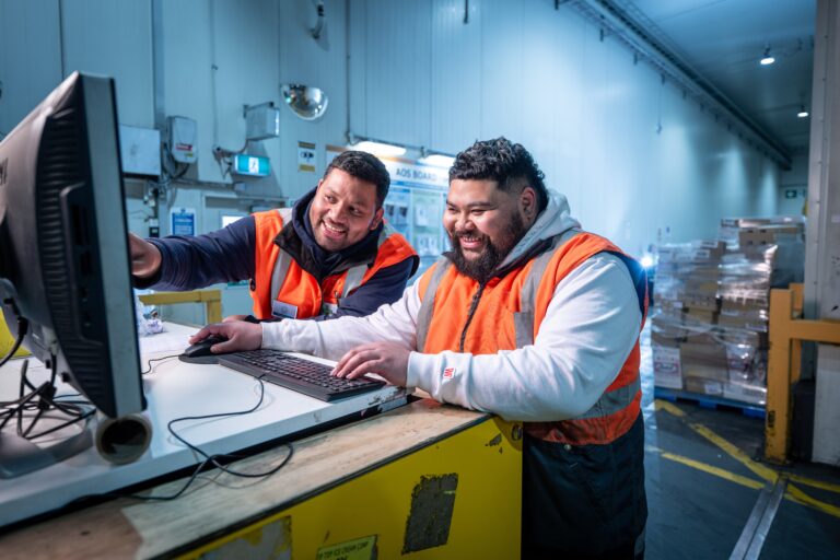 two men working on computer together