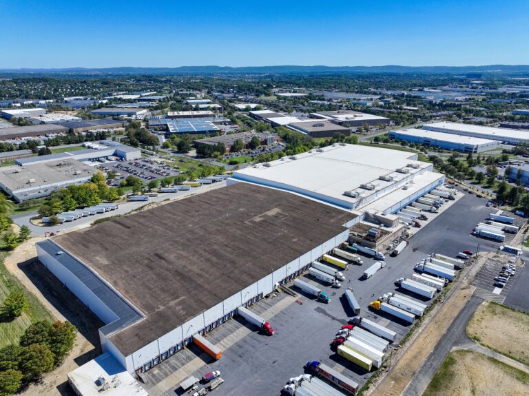 view of americold facility with trucks leaving