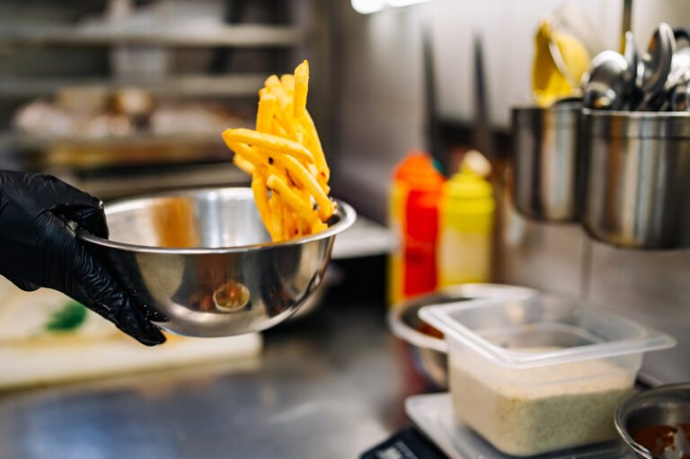 worker tossing fries in kitchen