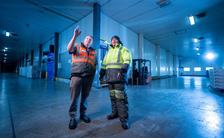 two workers talking together in warehouse