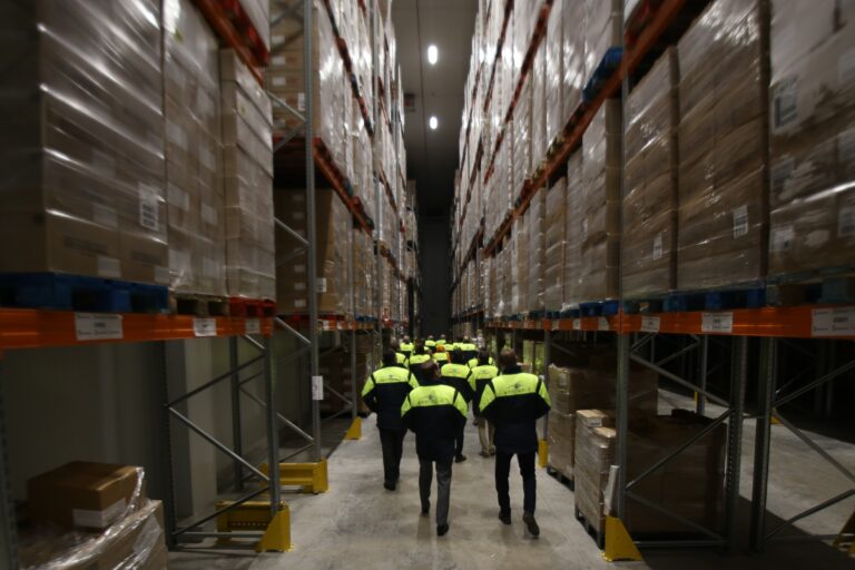 workers walking through shelves in facility